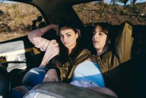 Women sitting on back seat in car — Stock Photo