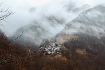 Pequena aldeia em montanha em nevoeiro — Fotografia de Stock