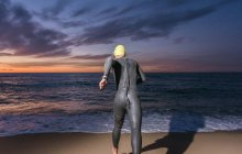 Триатлон бегает по песчаному пляжу — стоковое фото