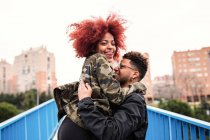 Junges Paar umarmt sich auf Brücke — Stockfoto