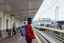 Человек, стоящий на железнодорожной станции — стоковое фото
