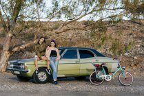 Жінки позують на зеленій машині — стокове фото