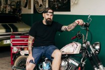 Tätowierter Mechaniker in Garage — Stockfoto