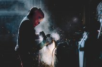 Mann arbeitet mit Schleifer, der Metall schneidet. — Stockfoto