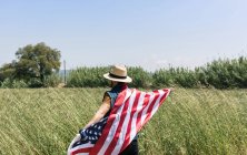 Homme au chapeau tenant le drapeau américain — Photo de stock