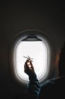 Woman shows airplane model in window. — Stock Photo