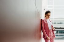 Frau im rosa Anzug steht auf der Straße — Stockfoto