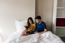 Paar benutzt Tablette im Bett — Stockfoto
