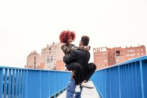 Uomo che trasporta fidanzata sul ponte — Foto stock
