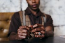Складывая руки сидящего черного человека — стоковое фото