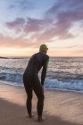 Triatleta de pie en el mar - foto de stock