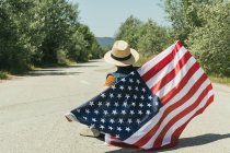 Hombre sosteniendo bandera americana - foto de stock