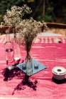 Kleine weiße, rustikale Blumen in Weinflaschen auf dem Tisch. — Stockfoto