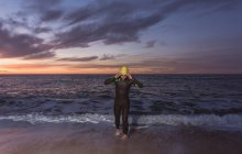 Triatleta caminando fuera del agua de mar - foto de stock