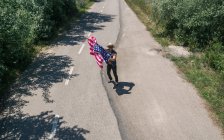 Homme au chapeau montrant drapeau américain — Photo de stock