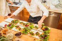 Женщина подает тарелки с салатом — стоковое фото