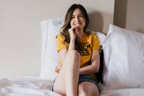 Mujer sonriente acostada en la cama - foto de stock