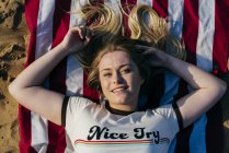 Mädchen liegt auf amerikanischer Flagge — Stockfoto