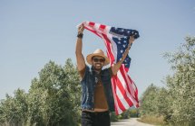 Homem de chapéu mostrando bandeira americana — Fotografia de Stock