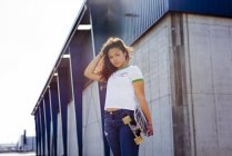 Adolescent fille debout avec skateboard — Photo de stock