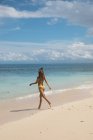Femme en bikini marchant sur la plage — Photo de stock