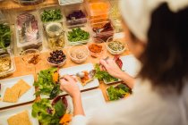 Assiettes de service femme avec salade — Photo de stock