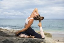 Woman stretching and posing at seaside — Stock Photo