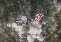 Two young women posing with USA flag on rocks. — Stock Photo
