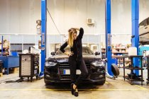 Femme posant dans un garage mécanique — Photo de stock