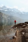 Вид сбоку на взрослого туриста, стоящего на спокойном озере в горах, Валензе, Швейцария — стоковое фото