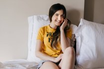 Sorridente donna sdraiata a letto — Foto stock
