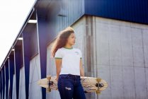 Adolescente in piedi con skateboard — Foto stock
