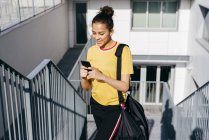 Sporty woman browsing on smartphone — Stock Photo