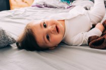 Divertente bambino sdraiato sul letto — Foto stock
