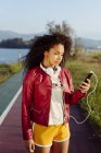 Teenage girl with smartphone standing on road — Stock Photo