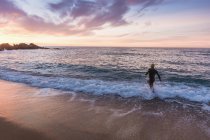 Triatleta correndo em mar ondulado — Fotografia de Stock