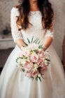 Crop unrecognizable bride with beautiful bunch of pink and white flowers. — Stock Photo