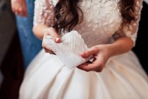 Рука допомагає невпізнаваній нареченій натиснути білу сукню . — стокове фото