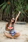 Frau mit Wassermelone am Strand — Stockfoto
