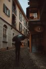 Чоловік ходить з парасолькою на міській вулиці — стокове фото