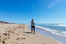 Femme courant le long de la plage de sable — Photo de stock