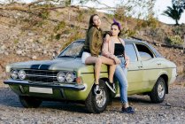 Women posing at vintage green car — Stock Photo