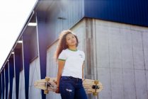 Девочка-подросток, стоящая со скейтбордом — стоковое фото