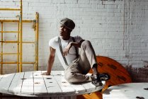 Чорний чоловік сидить на дерев'яному столі — стокове фото