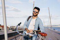 Chico con bicicleta y smartphone - foto de stock