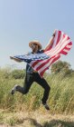 Людина перестрибуючи з американським прапором — стокове фото