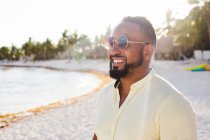 Людина в сонцезахисних окулярах стоїть на пляжі — стокове фото