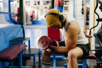 Man exercising with dumbbell in gym — Stock Photo