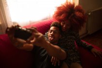 Couple taking photo with camera on couch — Stock Photo