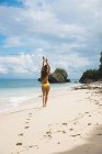 Donna in bikini che cammina sulla spiaggia — Foto stock